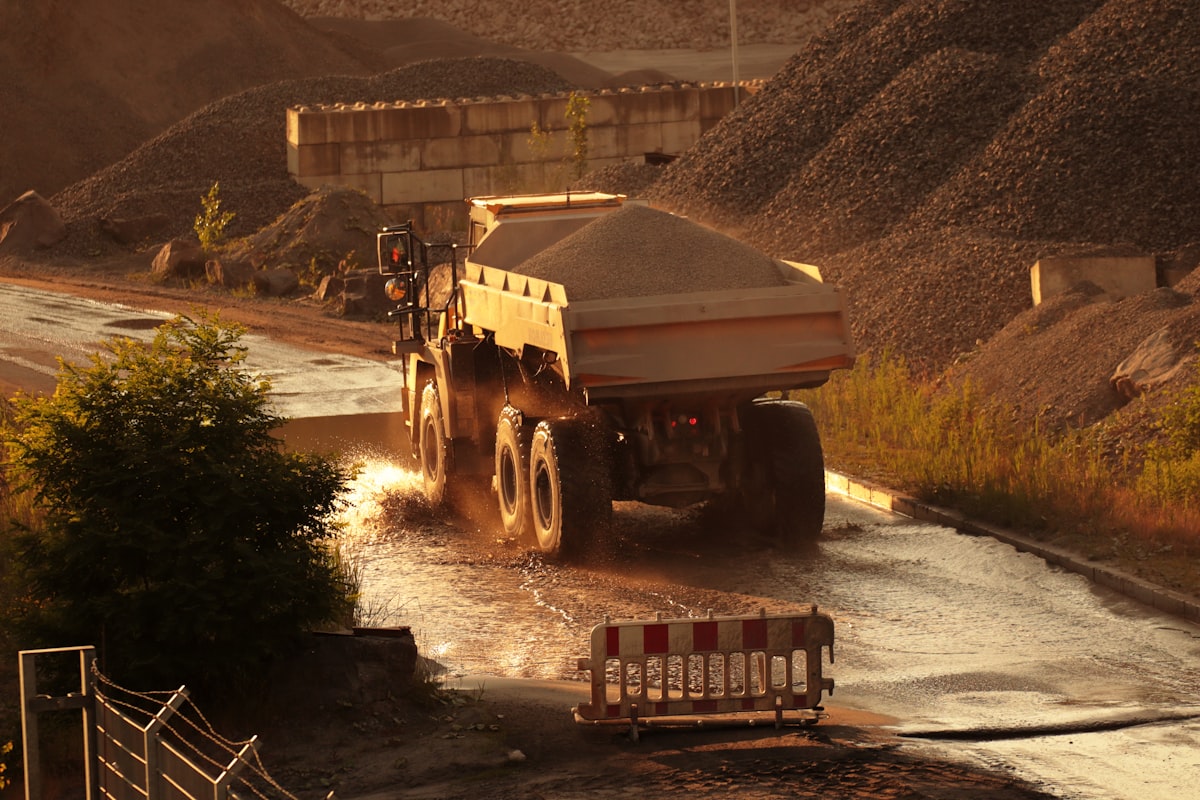 Site truck applying active water suppression on an unpaved access road