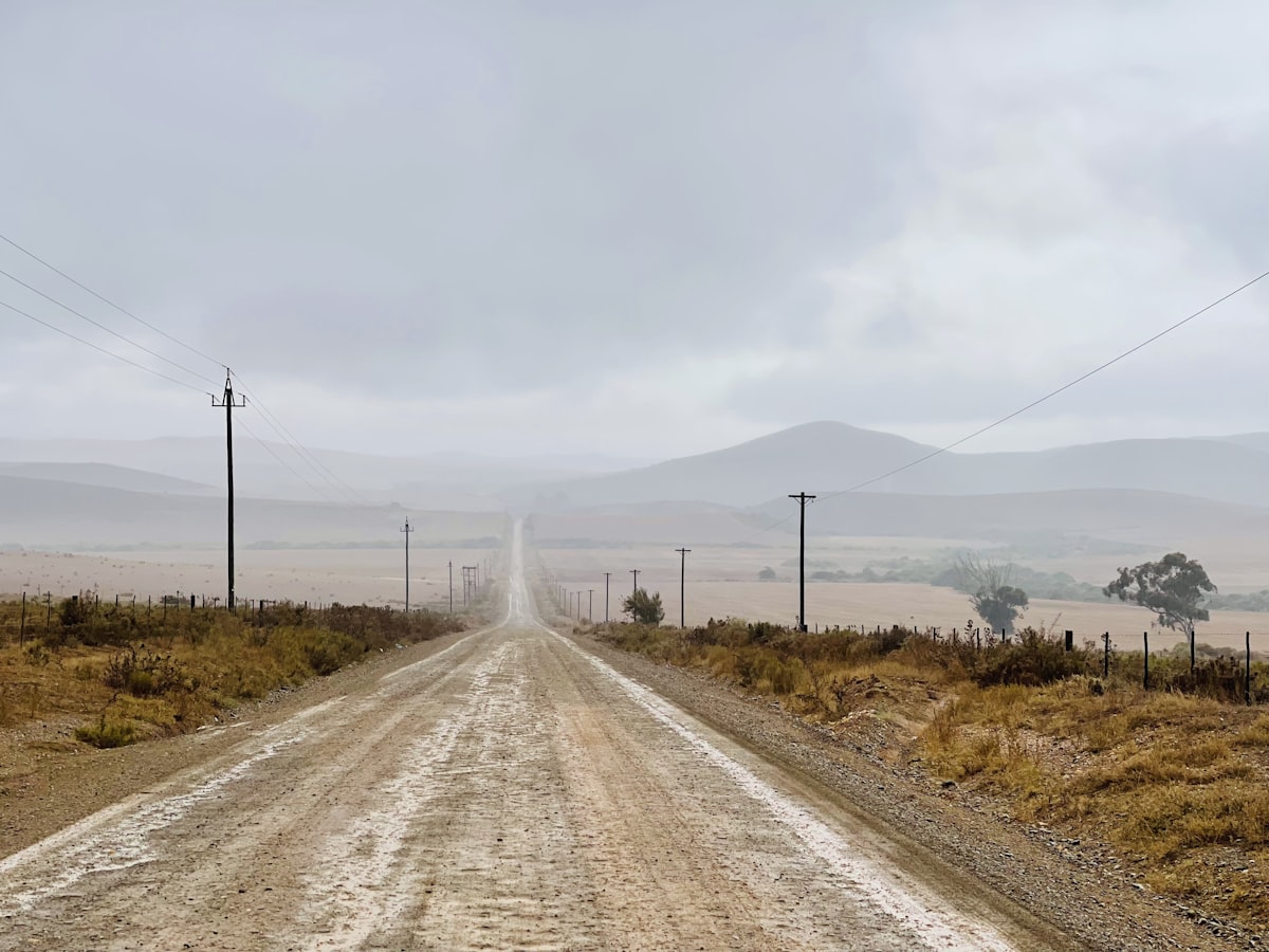 Stabilized unpaved community road running through arid landscape